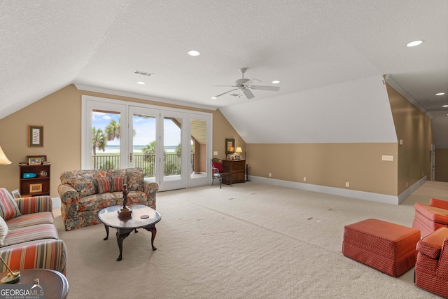 living area with baseboards, visible vents, vaulted ceiling, a textured ceiling, and carpet floors