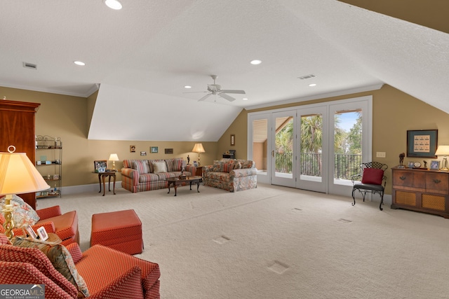 living area with light colored carpet, visible vents, lofted ceiling, and a textured ceiling