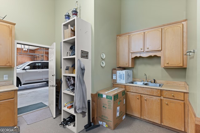 kitchen with light countertops, white microwave, a sink, and light brown cabinetry