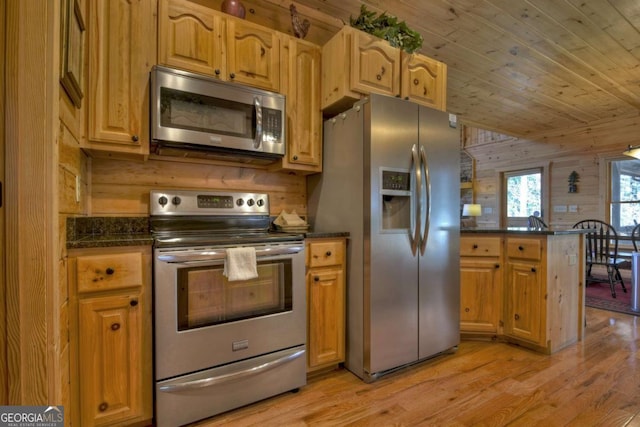 kitchen featuring wooden walls, stainless steel appliances, a peninsula, wood ceiling, and light wood-style floors