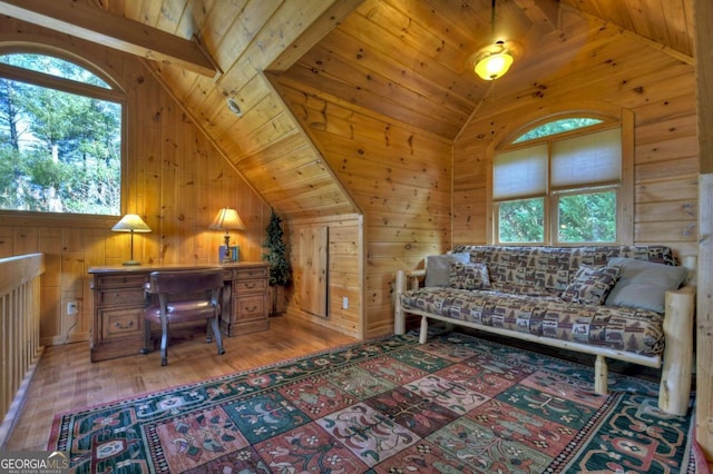 office space featuring lofted ceiling with beams, wood walls, wooden ceiling, and light wood finished floors