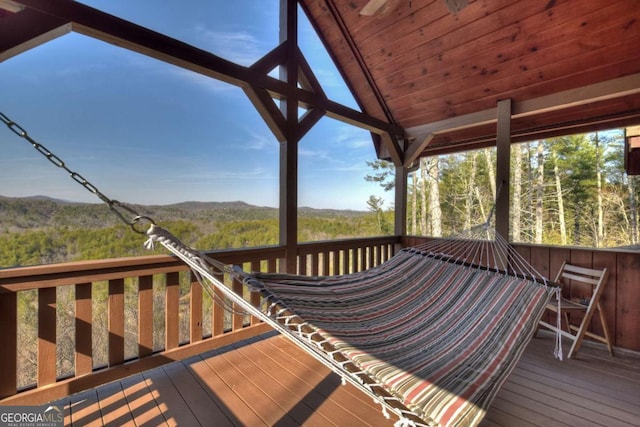 wooden terrace featuring a mountain view and a wooded view