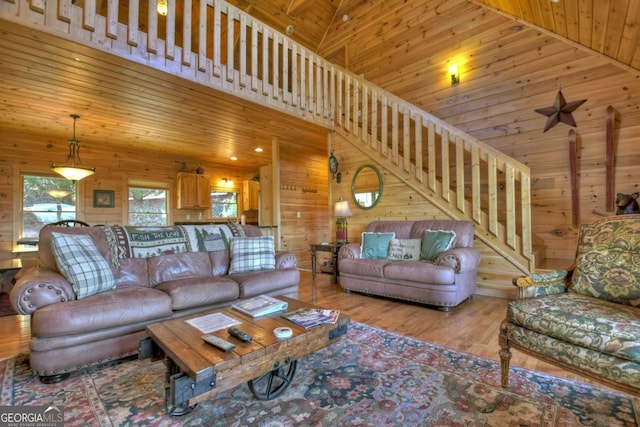 living room with wood ceiling, wood walls, and stairway