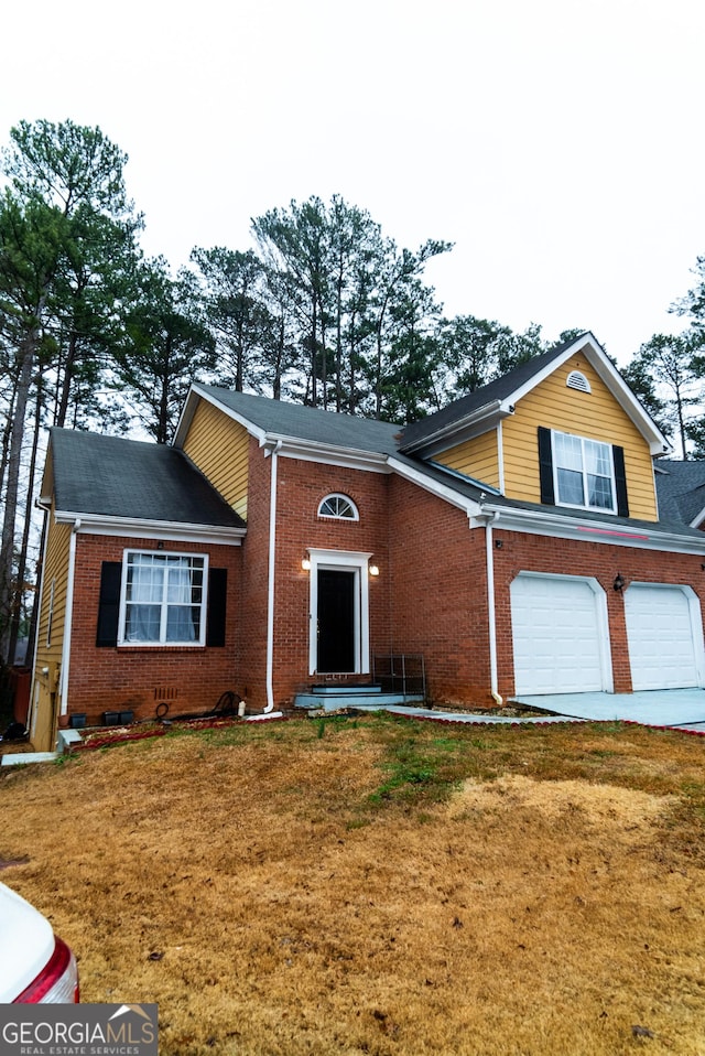 split level home featuring a garage, brick siding, driveway, and a front lawn