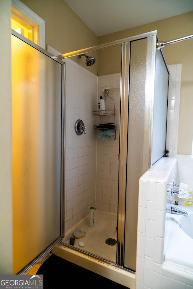 bathroom featuring a garden tub and a shower stall