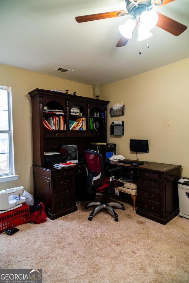 carpeted office space with a ceiling fan and visible vents