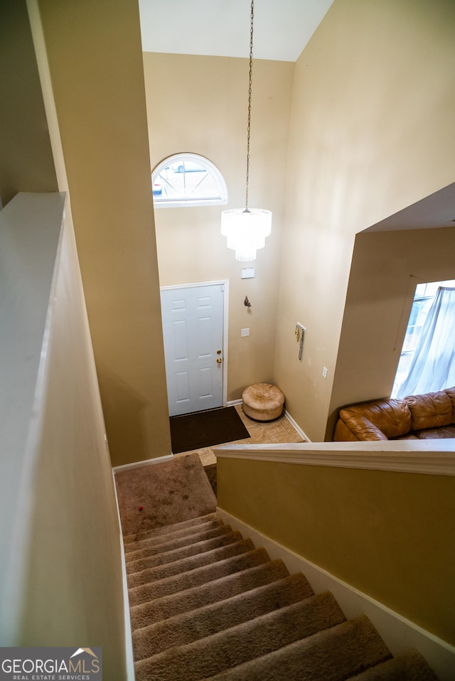 stairway featuring a towering ceiling