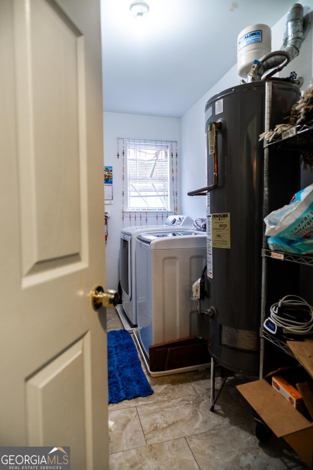 washroom with laundry area, water heater, and washer and clothes dryer