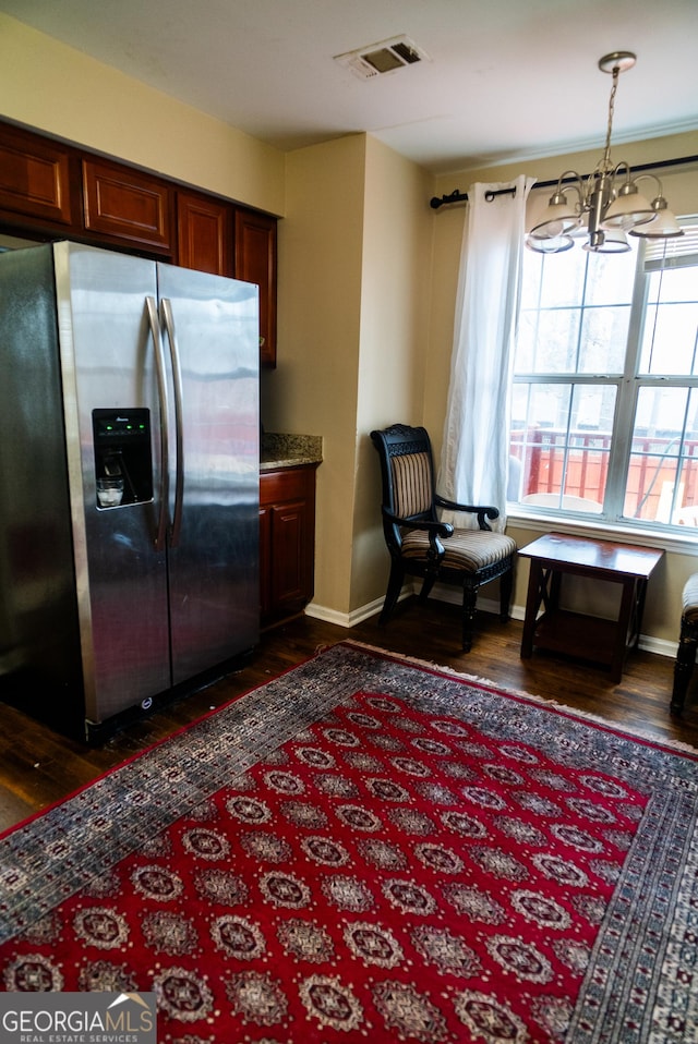 kitchen with dark wood-style flooring, visible vents, an inviting chandelier, stainless steel fridge, and baseboards