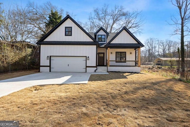 modern inspired farmhouse featuring a shingled roof, covered porch, and driveway