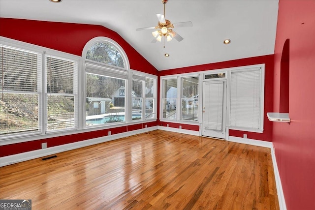 unfurnished sunroom featuring ceiling fan, visible vents, and vaulted ceiling