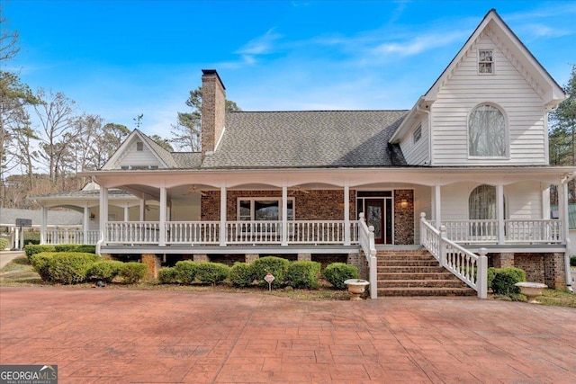 view of front of house with a chimney, a porch, and roof with shingles