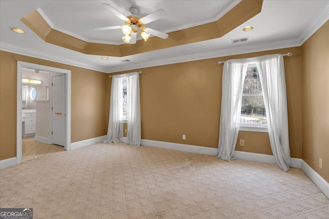 unfurnished bedroom featuring visible vents, baseboards, carpet, a raised ceiling, and crown molding