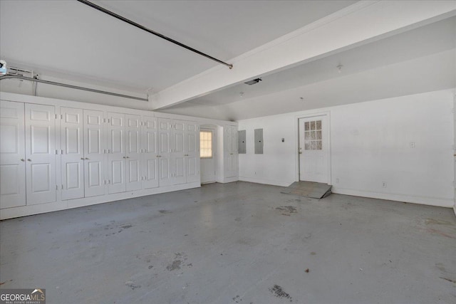 garage featuring electric panel and baseboards