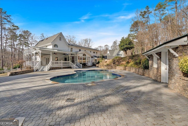 view of swimming pool featuring a patio area, ceiling fan, stairway, and a fenced in pool