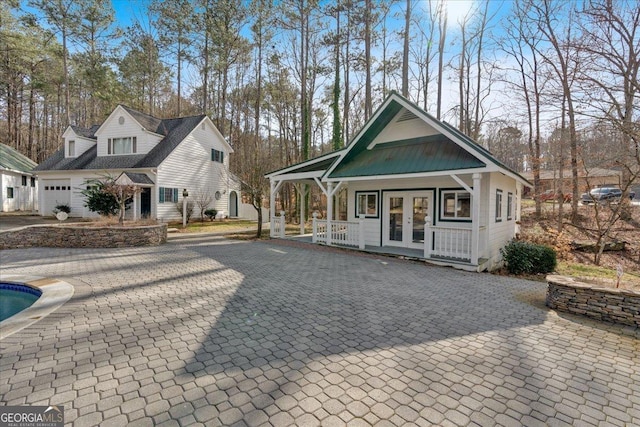 exterior space featuring covered porch and french doors