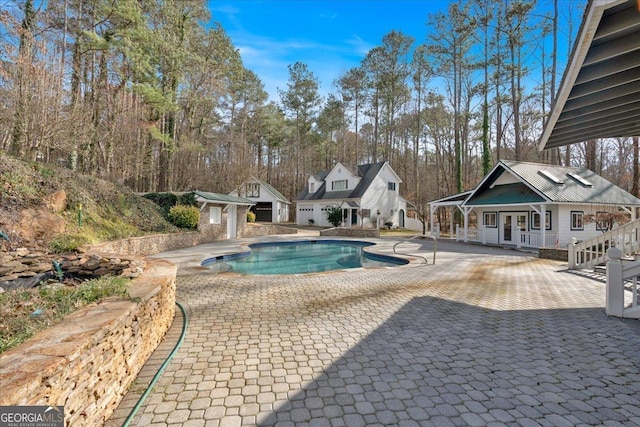 outdoor pool with a patio area, an outdoor structure, and french doors