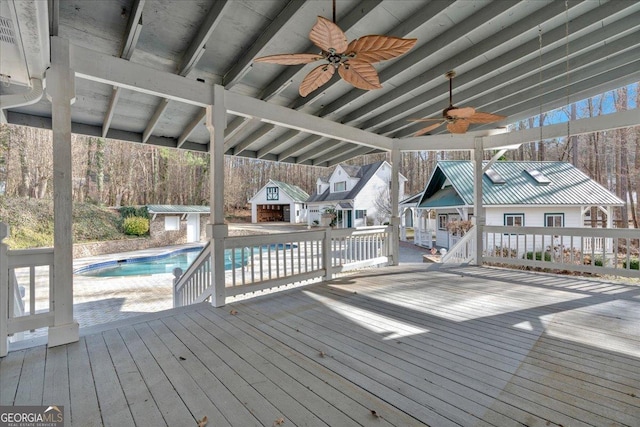 wooden deck featuring ceiling fan, a patio, an outdoor structure, and an outdoor pool