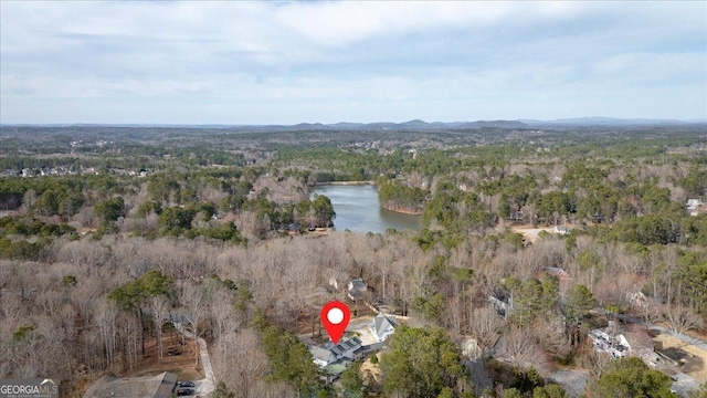 drone / aerial view with a forest view and a water view