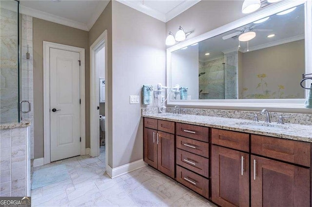 bathroom with a stall shower, crown molding, baseboards, and a sink