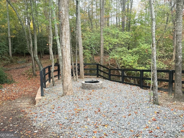 view of yard with an outdoor fire pit and fence