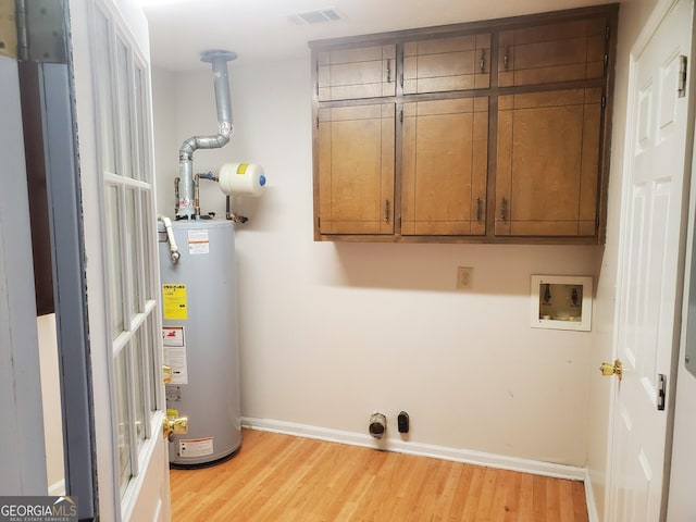 washroom featuring cabinet space, visible vents, gas water heater, light wood-style flooring, and electric dryer hookup