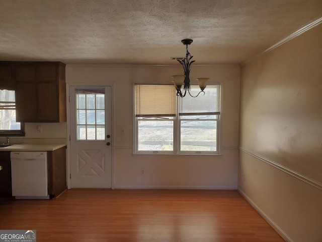 unfurnished dining area with a wealth of natural light, baseboards, and light wood-style flooring