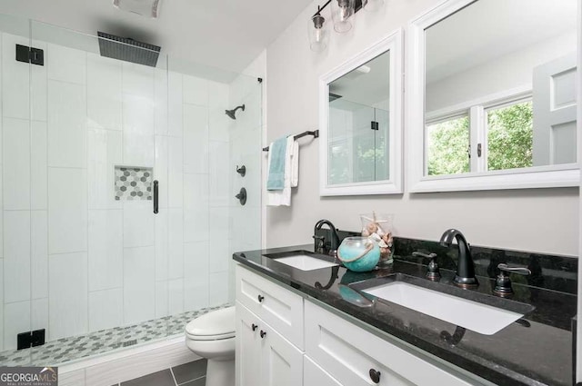 bathroom with a sink, toilet, and a shower stall