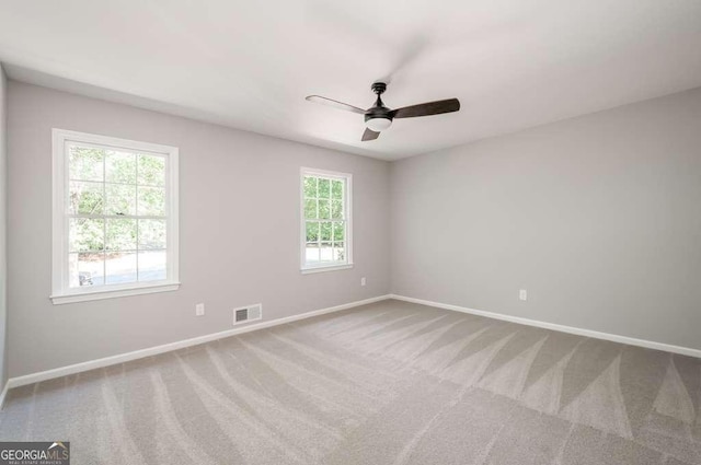 spare room featuring visible vents, baseboards, carpet, and a ceiling fan