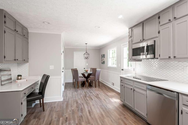 kitchen with light countertops, gray cabinets, and appliances with stainless steel finishes