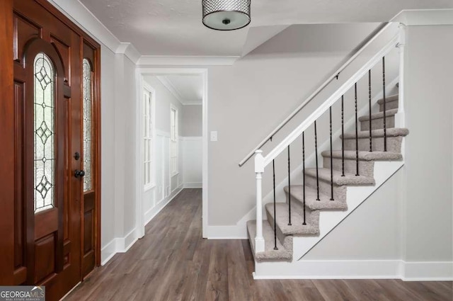 foyer entrance featuring stairway, ornamental molding, baseboards, and wood finished floors