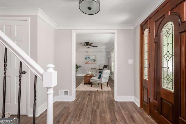 entryway with visible vents, baseboards, stairs, ornamental molding, and dark wood-style floors