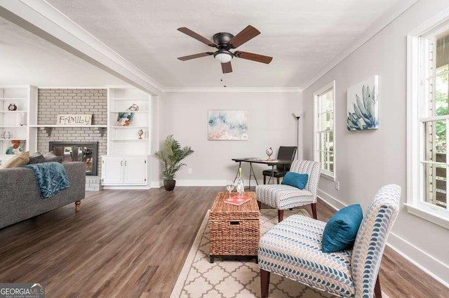 interior space with a fireplace, crown molding, wood finished floors, and baseboards