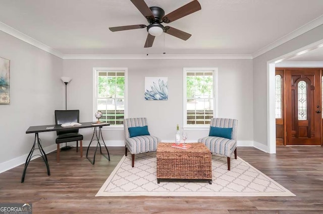 sitting room featuring crown molding, wood finished floors, baseboards, and a wealth of natural light