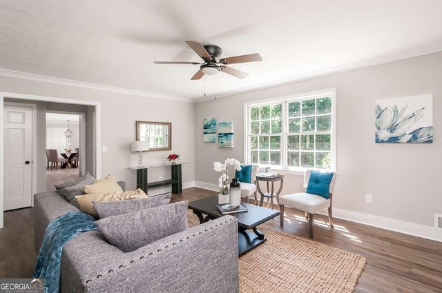 living room with a ceiling fan, wood finished floors, baseboards, and ornamental molding