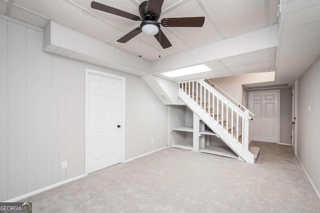 interior space with stairway, baseboards, a ceiling fan, and carpet flooring