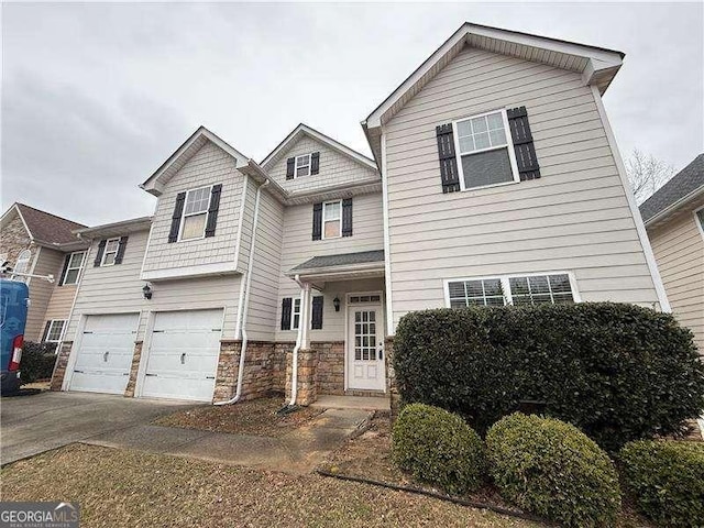 view of front of property with a garage, stone siding, and driveway