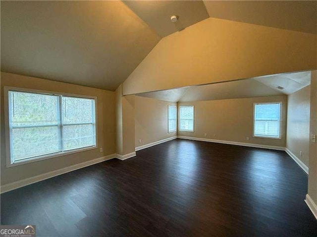 bonus room with lofted ceiling, dark wood-style floors, and baseboards