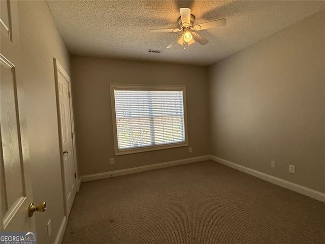 spare room featuring a ceiling fan, carpet, a textured ceiling, and baseboards