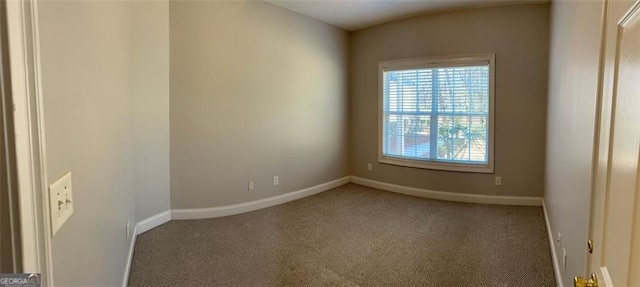 carpeted empty room featuring baseboards