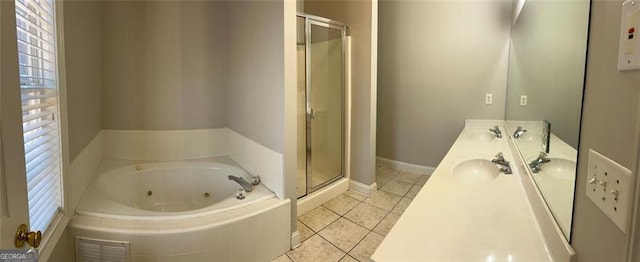 bathroom with a sink, a shower stall, a tub with jets, and tile patterned floors