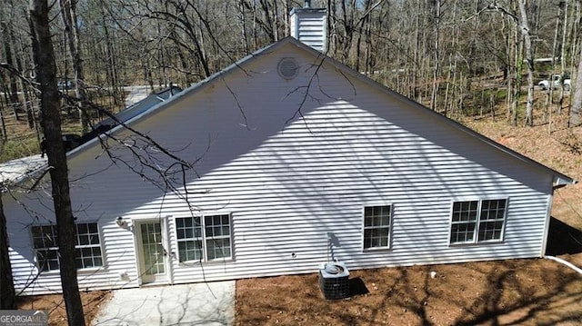 view of side of home with a patio and a chimney