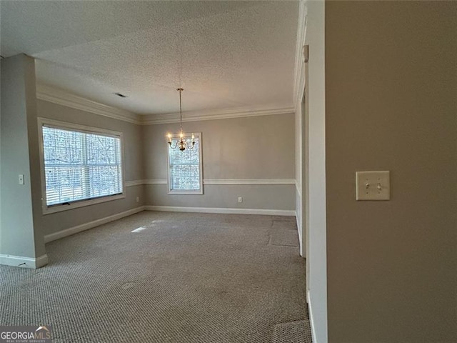 carpeted empty room featuring a chandelier, crown molding, a textured ceiling, and baseboards