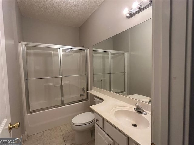 bathroom featuring bath / shower combo with glass door, toilet, tile patterned floors, a textured ceiling, and vanity