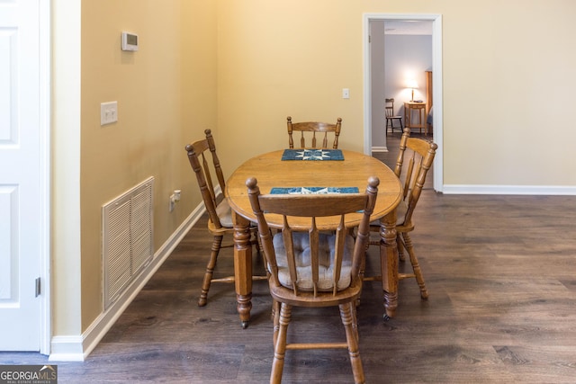 dining space featuring wood finished floors, visible vents, and baseboards