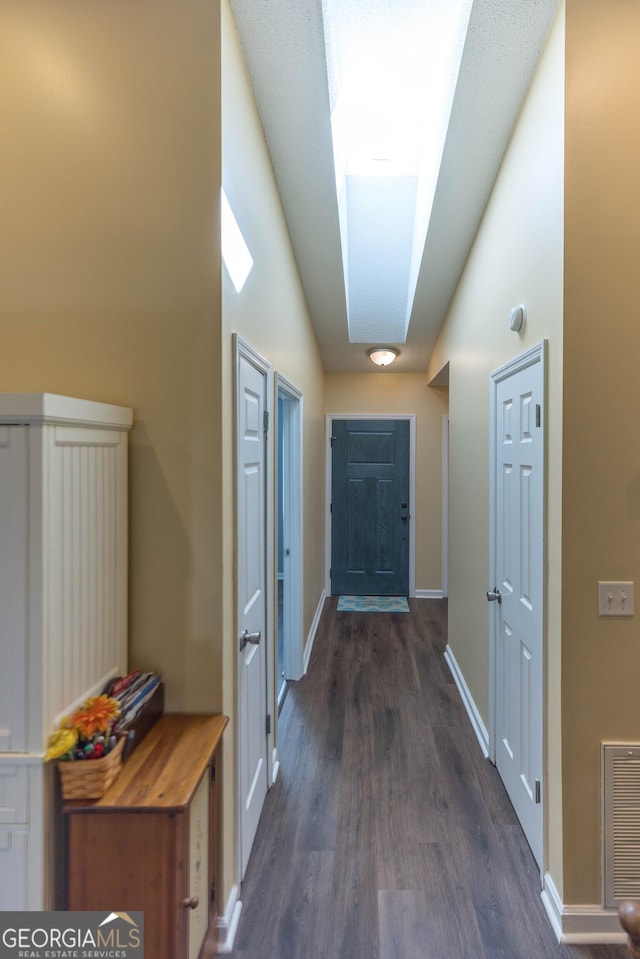 entryway featuring lofted ceiling, visible vents, dark wood finished floors, and baseboards