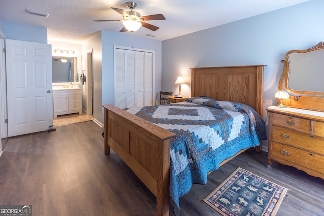 bedroom with dark wood-style floors, a closet, visible vents, and ceiling fan