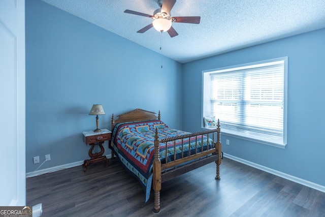 bedroom with a ceiling fan, a textured ceiling, baseboards, and wood finished floors