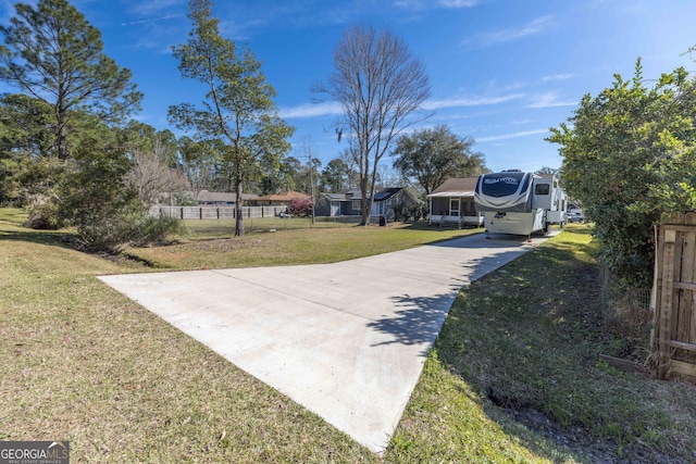 view of yard featuring driveway and fence