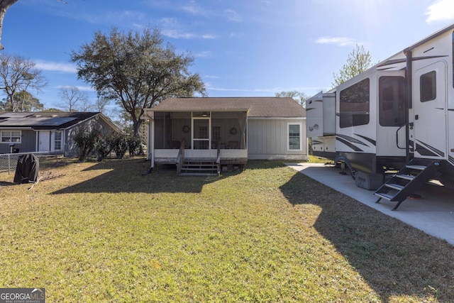 back of property featuring a sunroom and a yard